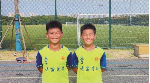 榕江县古州镇第四小学足球队队员韦朝益（左）和潘锦涛（右）在球场边。王明周 摄
